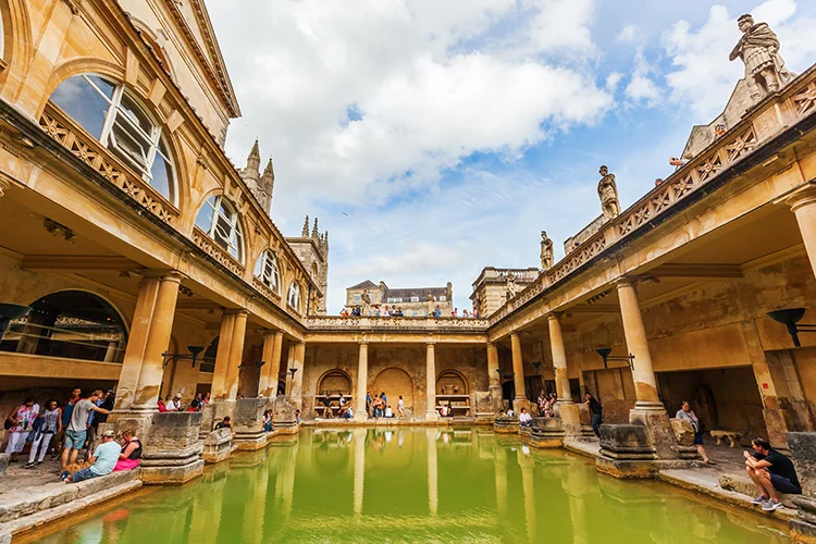 Roman Baths terrasse og Bath Abbey tårn bag med georgiske statuer langs øverste niveau